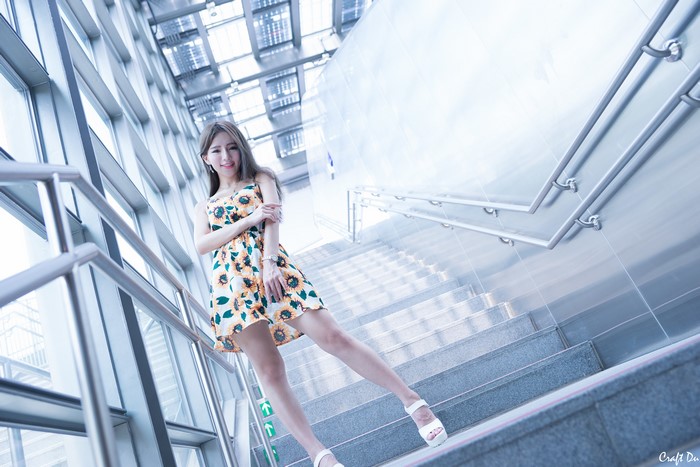 Asian woman in sunflower dress on stairs