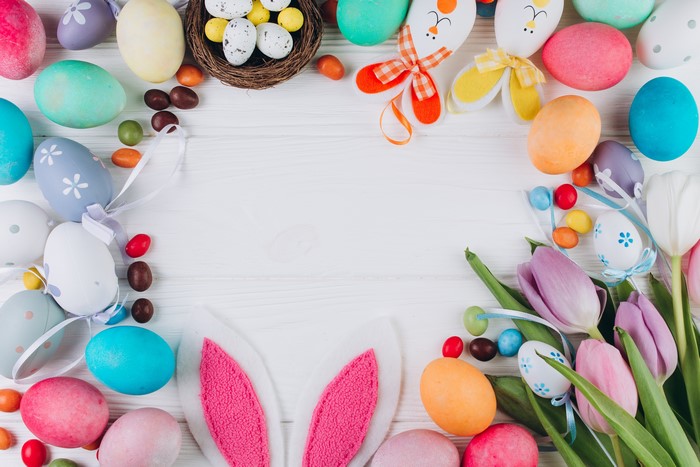 Easter eggs and tulips on a white wooden table