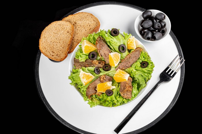 Salad with meat, oranges, olives, and bread
