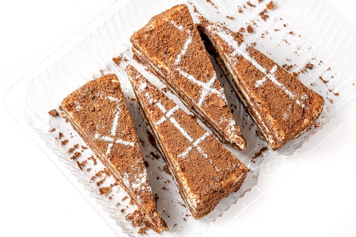 Four slices of chocolate cake with white frosting