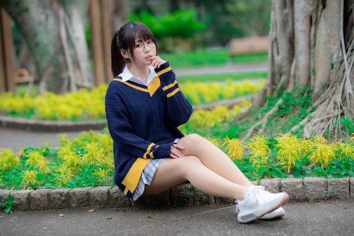 Asian girl in school uniform sitting in a park