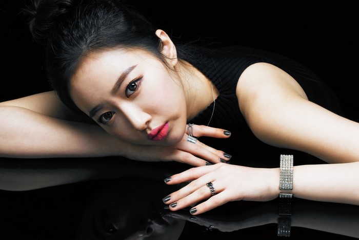 Asian woman with dark hair and makeup wearing rings and bracelet
