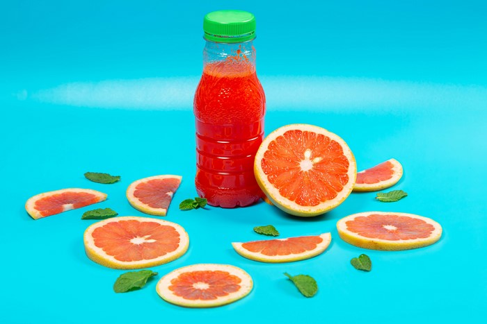 Grapefruit juice in a bottle with grapefruit slices and mint