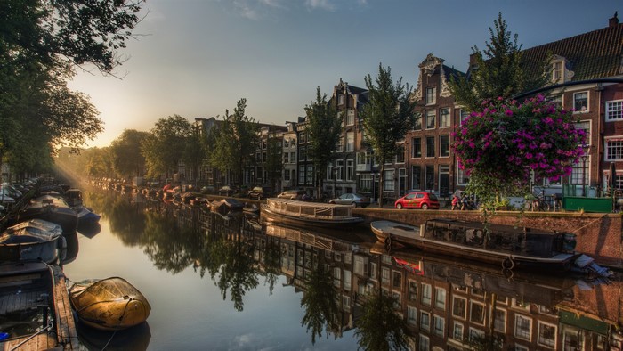 Amsterdam Canal at Sunrise with Boats and Buildings