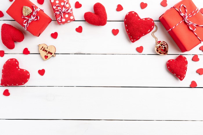 Valentine's Day red hearts and gifts on wood planks