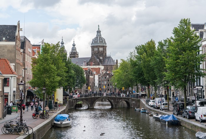 Amsterdam canal with bridges, boats, and trees