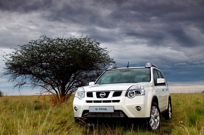 White Nissan X-Trail SUV in a grassy field