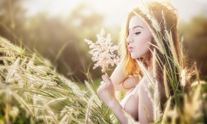 Woman in Grass Holding Flower