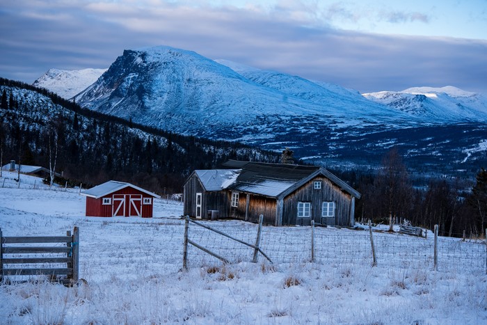 Winter scene with houses and snow-covered mountains in Norway