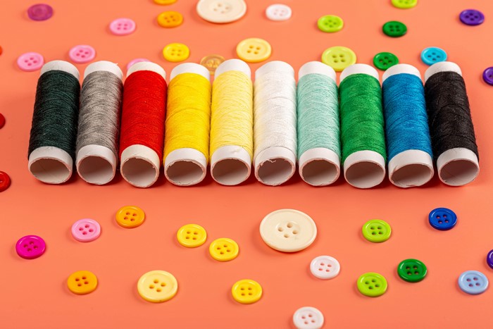 Many colored threads and buttons on a colored background
