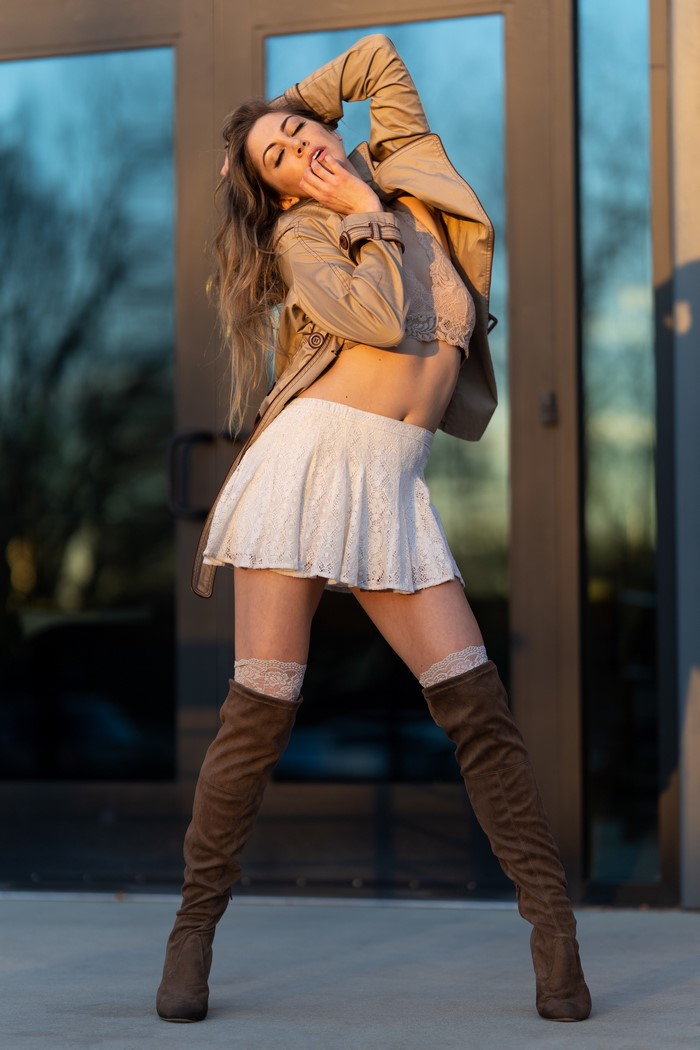 Korbi Kay posing in a jacket, skirt, and boots