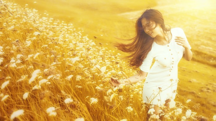 Asian woman in white dress in a field of flowers