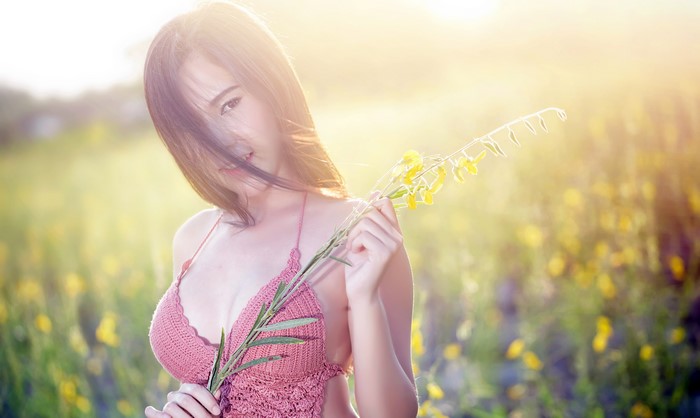 Asian woman with brown hair holding yellow flowers
