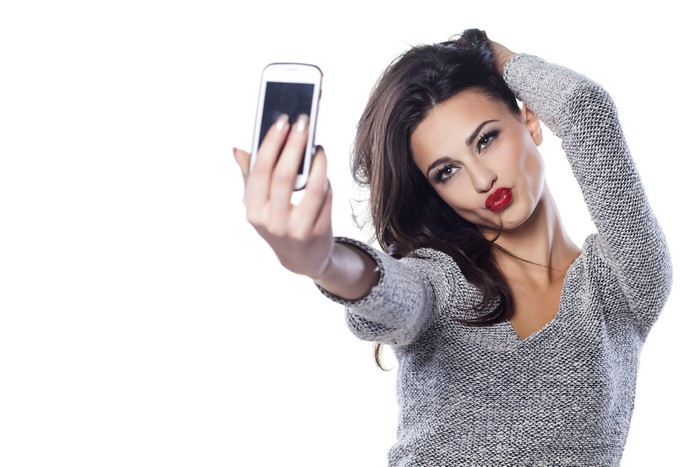 Brunette girl taking a selfie with red lips