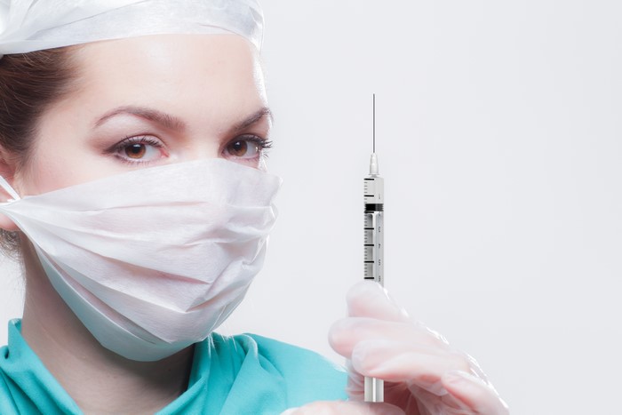 Medical doctor with syringe and mask