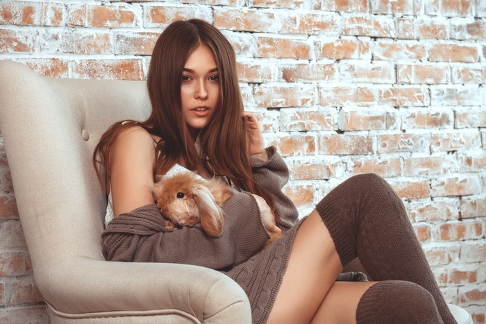 Woman with rabbit in armchair