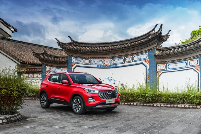 Red Chery Tiggo 5x Crossover parked near traditional Chinese architecture
