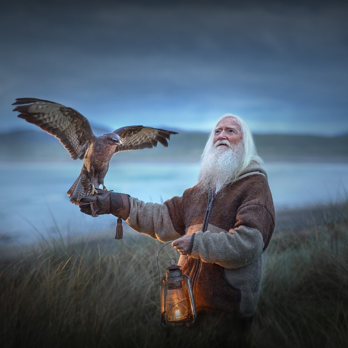 Old man with a hawk and a lantern