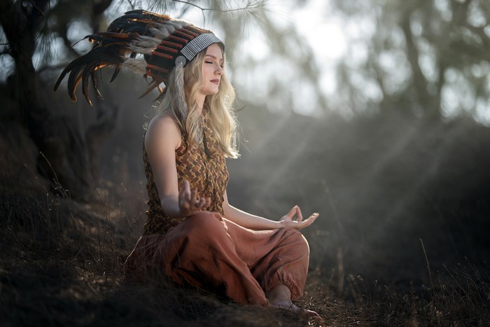 Woman in War Bonnet Meditating in Lotus Position