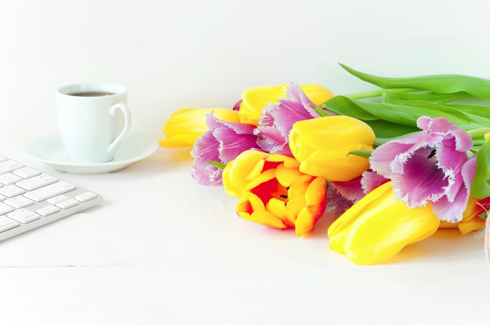 Tulips bouquet with coffee cup and keyboard