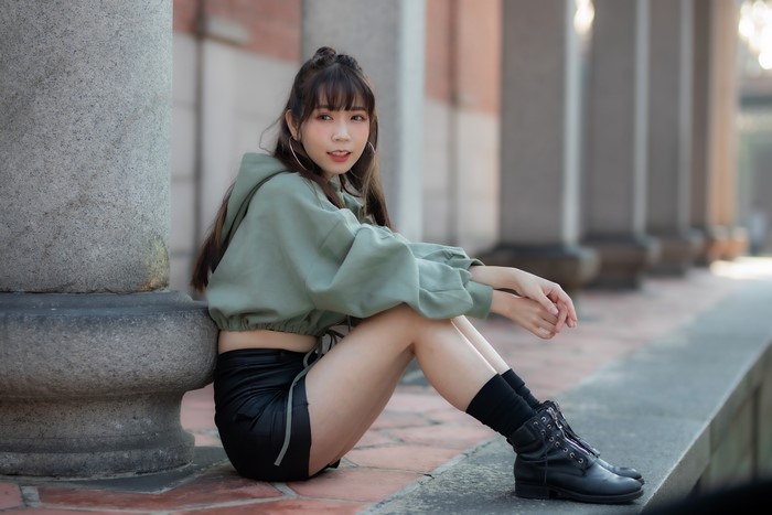 Asian woman sitting by pillars