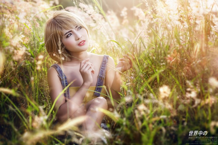 Asian blonde girl sitting in grass