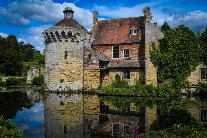 Castle and house reflected in a pond in Kilndown, England