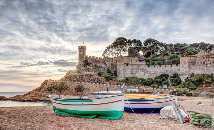 Boats on beach with Tossa de Mar fortress, Spain