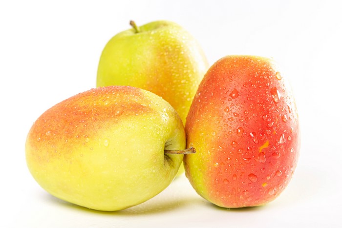 Three apples with water drops on white background