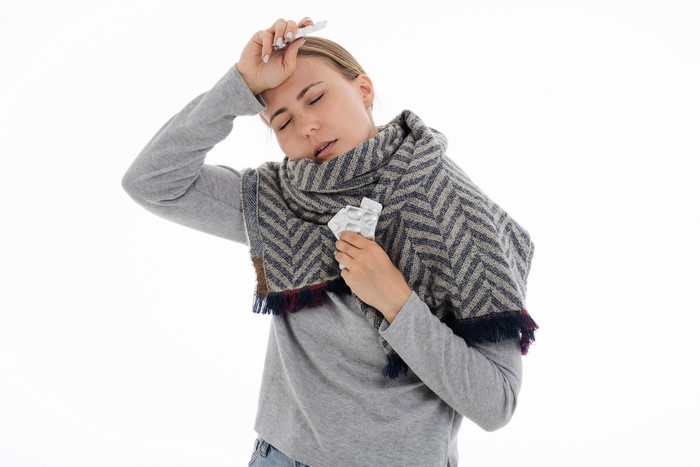 Woman with scarf and pills, common cold