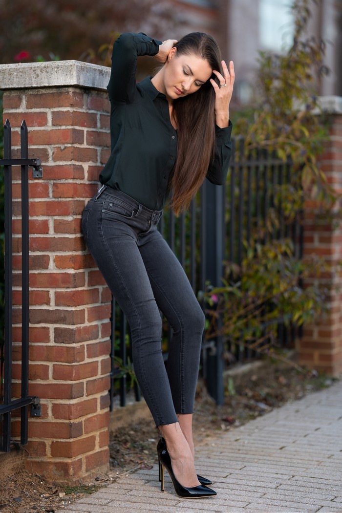 Woman in Jeans and Formal Shirt Posing by Brick Pillar