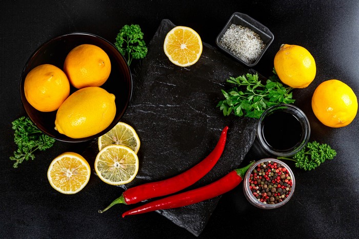 Lemons, Chili Peppers, and Spices on Black Surface