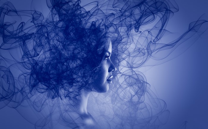 Woman's face emerging from blue smoke