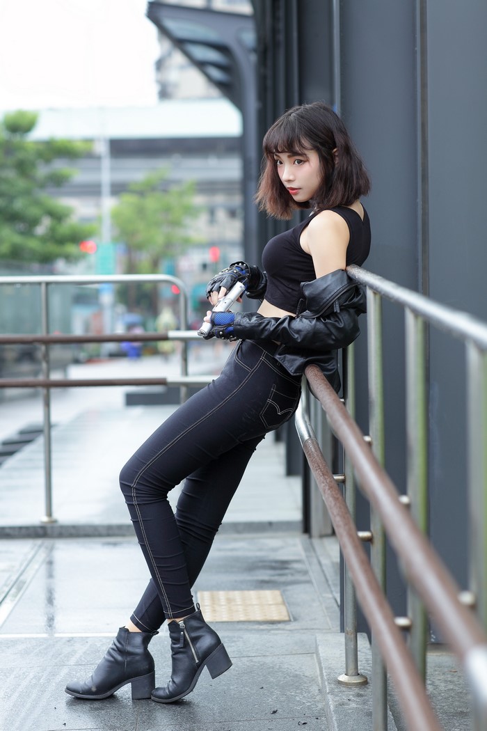 Asian woman in black outfit holding pistols