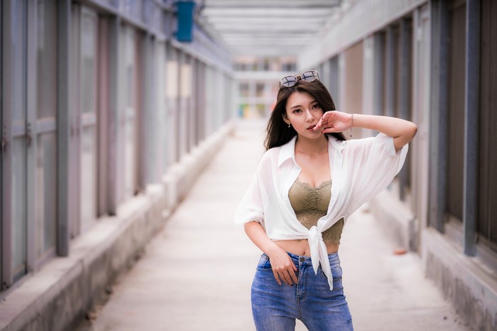 Asian woman in white shirt and jeans posing