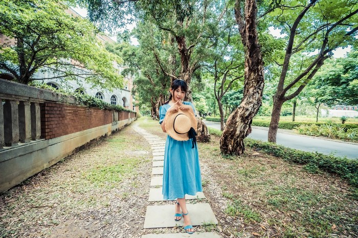 Asian girl in blue dress holding a hat