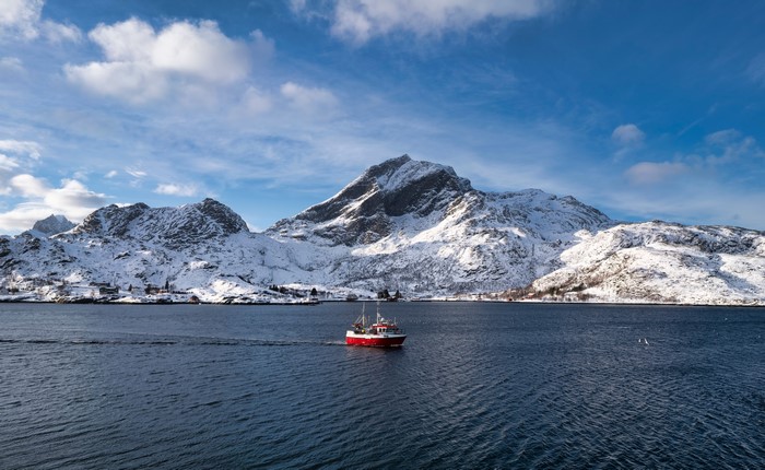 Motorboat near snow-covered Lofoten Mountains in Norway