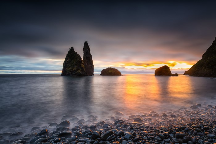 Sunset over a rocky bay with sea stacks