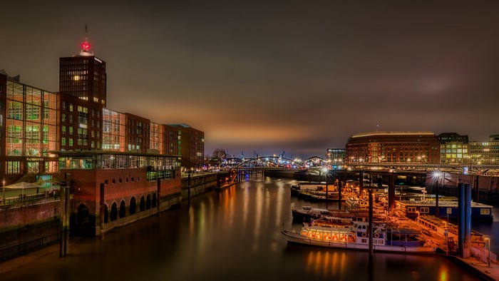 Hamburg harbor at night with illuminated buildings and boats
