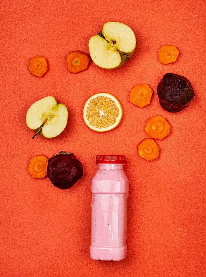 Apples, Carrots, Beet, Yogurt Drink on Orange Background