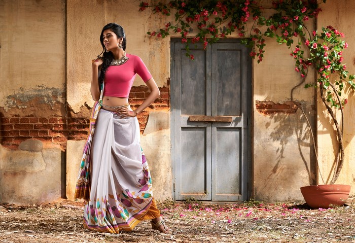 Brunette girl in Indian attire posing near a door