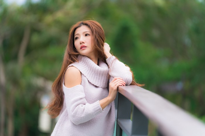 Asian woman with brown hair wearing a sweater