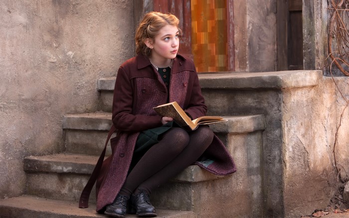 Sophie Nelis sitting on stairs with a book