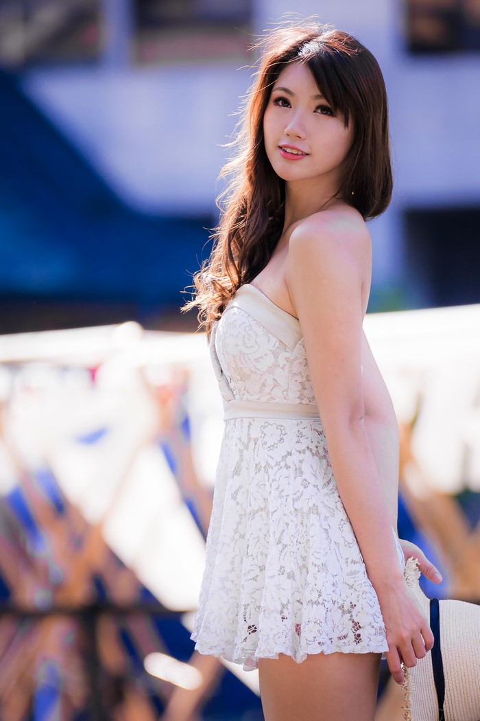 Asian woman in white lace dress with hat