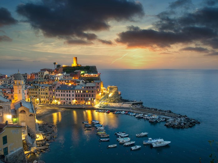 Vernazza, Italy at sunset with boats in the harbor