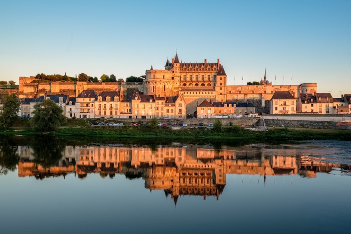 Amboise Castle reflected in a river at sunset, France