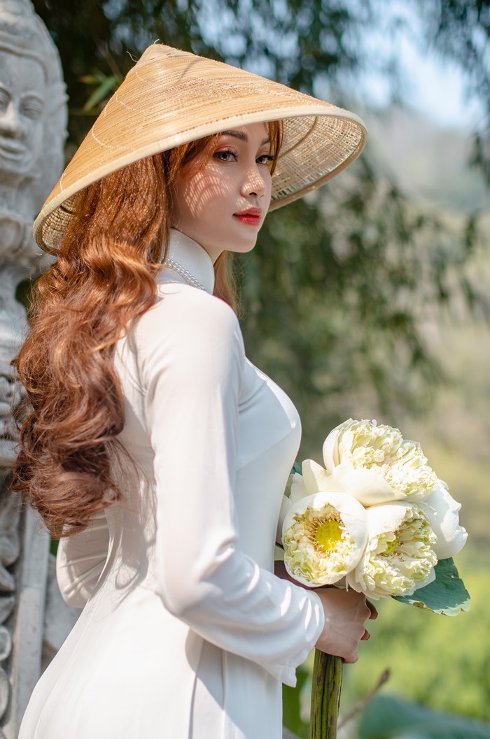 Asian Woman in Traditional Hat with White Flowers