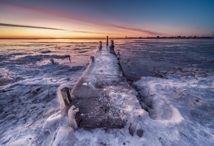 Frozen pier at Durgerdam, Netherlands during sunset
