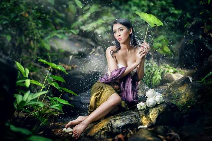 Brunette Girl Sitting on Stones with Water Splash