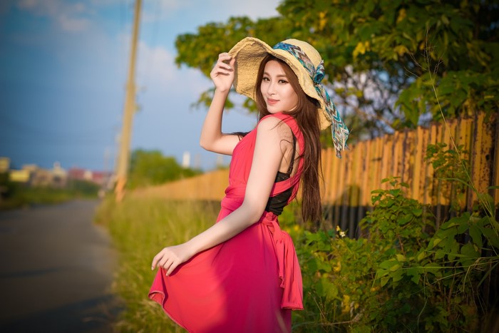 Asian woman in red dress and hat